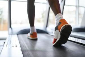 tillbaka se av oigenkännlig manlig ben löpning på löpband i Gym. foto