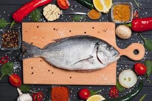 rå fisk matlagning och Ingredienser. dorado, citron, örter och kryddor. topp se med kopia Plats på tabell foto