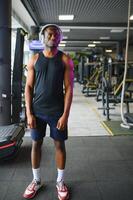 ung afrikan-amerikan man i en Gym framställning till övning foto