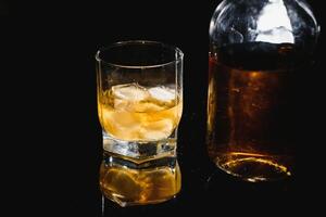 whisky glas svart bakgrund skinande foto