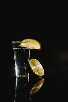 tequila med kalk och salt på svart bakgrund foto