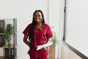 medicin, människor och sjukvård begrepp - afrikansk amerikan kvinna läkare eller sjuksköterska på sjukhus. foto
