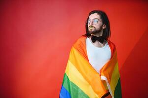 Lycklig Gay man har roligt innehav regnbåge flagga symbol av lgbtq gemenskap foto