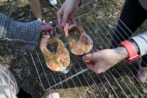 förberedelse av öring i kryddor till steka på utegrill utomhus. foto