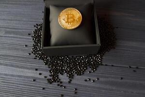 gyllene bitcoin i en svart låda. guld mynt av kryptovaluta. foto