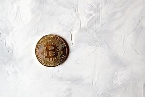 gyllene bitcoin på de vit texturerad bakgrund med tömma Plats. foto