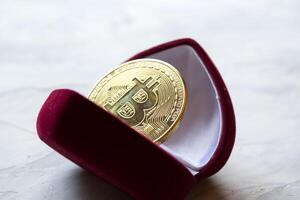gyllene bitcoin i röd låda. en mynt av kryptovaluta. foto