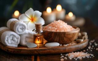 en lugn spa arrangemang terar himalayan salt, grundläggande oljor, frangipani blommar, och ljus foto