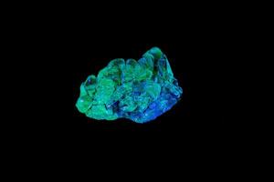 makro mineral sten opal under ultraviolett ljus på en svart bakgrund foto