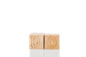 trä- kuber med brev do på en vit bakgrund foto