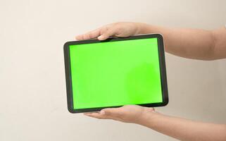 hand är innehav en flik med grön skärm på en vit isolerat bakgrund foto