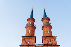 de moské är tillverkad av röd tegel. minaret. en majestätisk religiös byggnad. de hus av Gud. en plats för böner av troende. foto