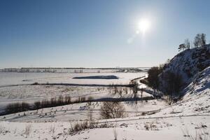 ljus solljus mot de himmel. vinter- landskap i Ryssland, blå sjö bashkortostan, natur av de sydlig uraler. foto