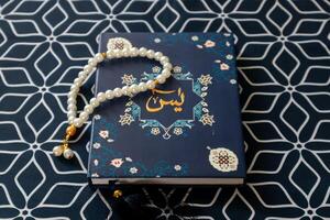 en surah yaseen eller yasin bok och bön pärlor på en bön matta foto