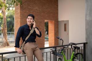 eco vänlig, Lycklig livsstil asiatisk ung affärsman rida cykel gå till kontor arbete på stad gata med cykel i morgon- foto