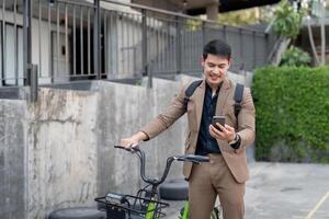 asiatisk affärsman i en kostym är ridning en cykel på de stad gator för hans morgon- pendla till arbete. eco transport begrepp, hållbar livsstil begrepp foto