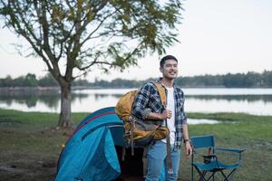 man asiatisk reser med tält camping på berg topp utomhus äventyr livsstil vandring aktiva sommar semester foto