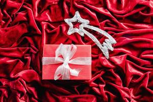 stjärnskott och gåva på röd sammet bakgrund. juldekoration foto