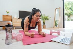 asiatisk övervikt kvinna håller på med stretching övning på Hem på kondition , uppkopplad kondition klass. stretching Träning träna på yoga matta på Hem för Bra hälsa och kropp form foto