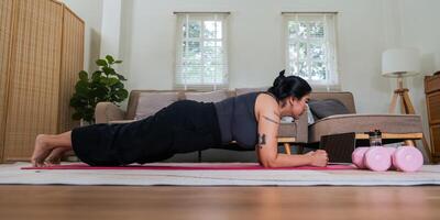 asiatisk övervikt kvinna håller på med stretching övning på Hem på kondition , uppkopplad kondition klass. stretching Träning träna på yoga matta på Hem för Bra hälsa och kropp form foto