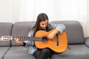 skön ung flicka spelar gitarr på Hem foto