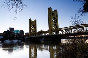 sacramento, ca, 2012 - torn bro och sacramento flod tidigt morgon- blå himmel foto