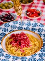 kock häller oliv olja på spaghetti med tonfisk foto