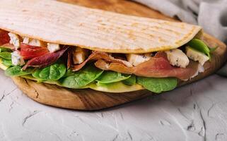 piadina - klassisk italiensk tortilla-bröd med skinka, basilika och dor blå foto