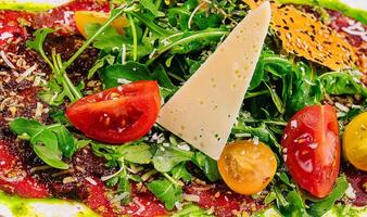 nötkött carpaccio med parmesan och arugula stänga upp foto