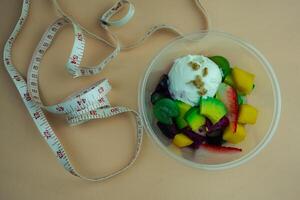 frukt, terar en mängd av färsk frukt och ett färsk yoghurt skopa och med vit mätning tejp foto