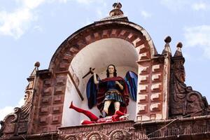 cusco, peru, 2015 - staty av ängel och jäkel på topp av katolik kyrka söder Amerika foto