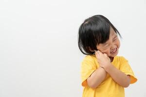 liten asiatisk flicka trycker på hand till kind, lider från smärta i tand. tänder förfall, dental problem, barn känslor och ansiktsbehandling uttryck, oral hälsa vård, minska sötsaker, fluor beläggning foto