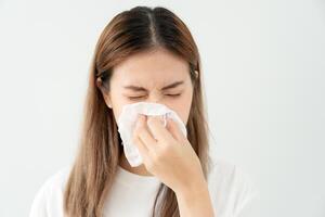pollen allergier, asiatisk ung kvinna nysning i en näsduk eller blåser i en torka, allergisk till vild vår blommor eller blommar under vår. allergisk reaktion, respiratorisk systemet problem foto