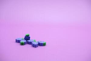 lila bakgrund med druva leksaker. druvformad suddgummi isolerat på lila bakgrund. foto