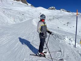 en person på skidor på en snöig backe foto