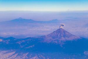 flygande flygplan över mexico moln himmel vulkaner bergen stad öken. foto