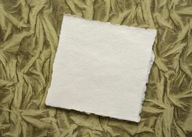 små ark av tom vit khadi trasa papper mot konst papper bakgrund foto
