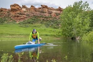 senior manlig paddlare på en touring stå upp paddelbräda på sjö i colorado foten - hästtand reservoar nära fort collins foto