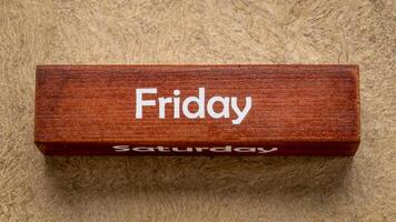 fredag och lördag text på trä- blockera mot handgjort bark papper i jord toner, kalender begrepp foto