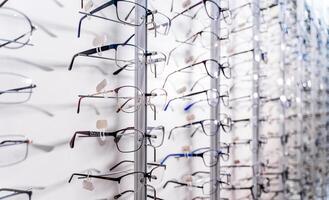 rad av glasögon på ett optiker. glasögon affär. stå med glasögon i de Lagra av optik. monter med glasögon i modern oftalmisk Lagra. närbild. foto