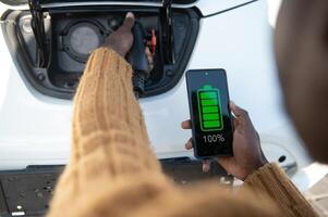 smartphone app visar laddning status av de elektrisk bil batteri. elektro transport begrepp foto