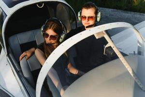 ung kvinna och pilot i i de cockpit av en plan. främre se foto