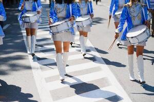 majorettes med vit och blå uniformer prestera i de gator av de stad. fotografisk serier foto