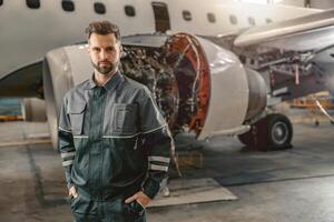 manlig flygbolag mekaniker stående nära flygplan i hangar foto