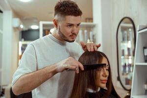 professionell manlig frisör framställning frisyr till kvinna på skönhet salong foto
