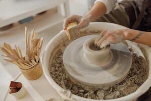 stänga upp av händer av professionell krukmakare gjutning pott form på krukmakeri hjul. keramik konst begrepp foto