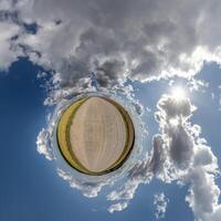 enkel grön mycket liten planet utan byggnader i blå himmel med skön moln. omvandling av sfärisk panorama 360 grader. sfärisk abstrakt antenn se. krökning av Plats. foto