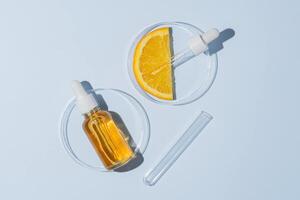 citrus- labb forskning. kosmetika produktioner, a ha komponenter extraktion. hud vård kosmetologi testning. petri maträtter med ansikte serum och orange frukt skiva Nästa till testa rör foto