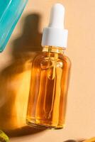glas kosmetisk flaska med en dropper på en beige bakgrund. naturlig kosmetika begrepp, naturlig grundläggande olja och hud vård Produkter, attrapp foto