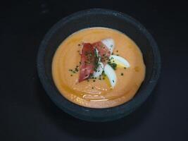 kall tomat soppa spanska stil eras i en maträtt isolerat på mörk bakgrund topp se foto